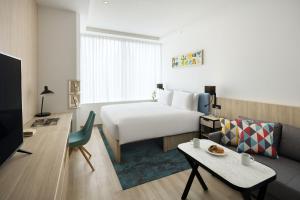 東京にあるハイアット ハウス 東京 渋谷のベッドとリビングルームが備わるホテルルームです。