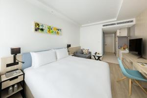 1 dormitorio con 1 cama blanca y 1 silla azul en Hyatt House Tokyo Shibuya, en Tokio