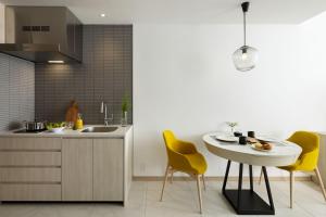 a kitchen with a table and two yellow chairs at Hyatt House Tokyo Shibuya in Tokyo