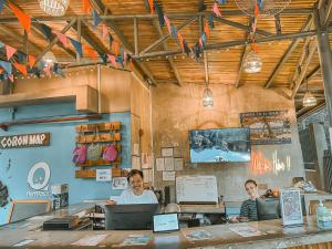 dos personas sentadas en un mostrador en un restaurante en Outpost Hostel - Coron en Corón