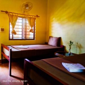 een kamer met 2 bedden en een raam bij The Mango Tree Guesthouse in Kampot