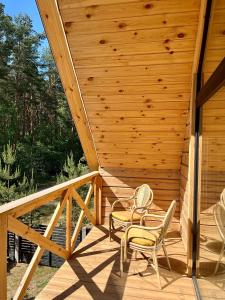a wooden deck with two chairs and chairs on it at Labieši in Jūrmala