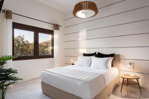 um quarto branco com uma cama e uma janela em Aniv Villa by the Sea em Kinion