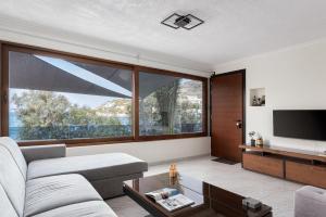 Aniv Villa by the Sea في كينيون: غرفة معيشة مع أريكة ونافذة كبيرة
