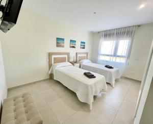 um quarto de hospital com duas camas e uma janela em OCEAN HOMES Apartamentos exclusivos en Isla Canela by AC REAL em Isla Canela