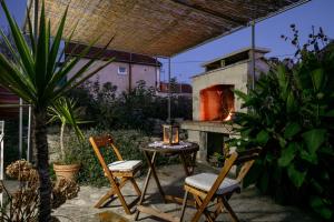 a patio with a table and chairs and a pizza oven at Stone House Harmony in Korčula