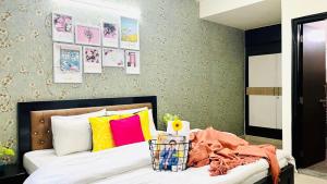 Olive Service Apartments - Vaishali Nagar في جايبور: غرفة نوم مع سرير مع وسائد ملونة
