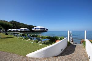 a row of chairs and umbrellas next to the ocean at Dimora del Leone Gaeta in Gaeta