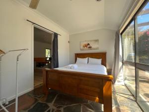 a bedroom with a bed and a large window at Young Woods Lodge in Rotorua