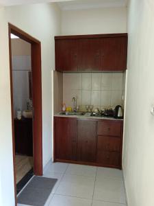 - une cuisine avec des placards en bois et un évier dans l'établissement Ketut Kasta Guest House, à Ubud