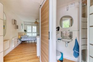 - un couloir avec une salle de bains pourvue d'un lavabo et d'un miroir dans l'établissement Charmant studio à 5 minutes de la mer à pied, à Saint-Nazaire