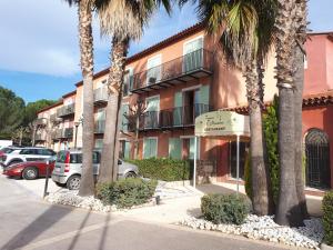 un edificio con palmeras frente a un aparcamiento en Studio, en Mouans-Sartoux