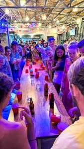 コロンにあるOutpost Hostel - Coronの長いテーブルの周りに立って飲み物を飲む人々