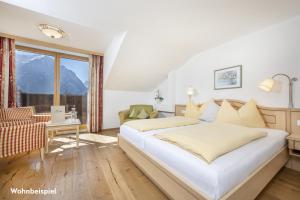 sypialnia z dużym białym łóżkiem i oknem w obiekcie Gasthof Kleefeld w mieście Strobl