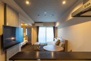 een hotelkamer met een tafel en een woonkamer bij INOVA Kanazawa Station Hotel Suite in Kanazawa