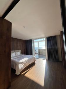 a bedroom with a large bed and a large window at KIM Apartments in Vung Tau