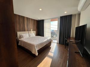 um quarto com uma cama e uma televisão de ecrã plano em KIM Apartments em Vung Tau