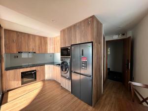 uma cozinha com um frigorífico de aço inoxidável e armários de madeira em KIM Apartments em Vung Tau