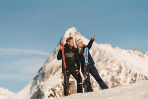 two people standing on top of a snow covered mountain at ZillergrundRock Luxury Mountain Resort in Mayrhofen