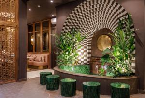 a lobby with a seating area with green stools at Riad Nyla Wellness and Spa in Marrakesh