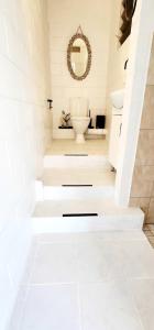 bagno bianco con servizi igienici e specchio di The Haven View - Airlie Beach ad Airlie Beach