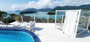 a patio with a pool and a view of the ocean at The Haven View - Airlie Beach in Airlie Beach