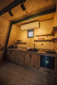 una cocina con armarios de madera y un lavabo en una cabaña en KARMATTE BUNGALOW, en Kartepe
