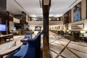 a lobby of a hotel with blue chairs and tables at Boudl Heraa in Jeddah