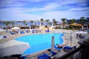 a pool with chairs and umbrellas in a resort at Royal Club 24 Hours All Inclusive - Marina Sharm in Sharm El Sheikh