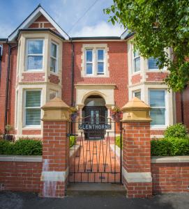 uma casa de tijolos com um portão em frente em Studios At Glenthorne em Merthyr Tydfil