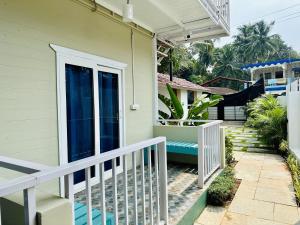 una casa con barandilla blanca y porche en Coco Hostel Goa en Palolem