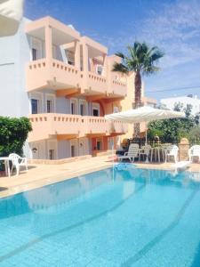 a large house with a swimming pool in front of a building at Toulipa Rooms in Agia Ermioni