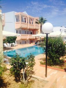 a building with a swimming pool in front of a house at Toulipa Rooms in Agia Ermioni