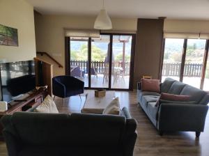 a living room with two couches and a tv at Roses Villa in Trimiklini