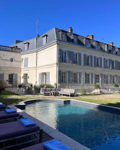 un gran edificio con una piscina frente a él en Le Clos des Fées en Asnières-sur-Oise