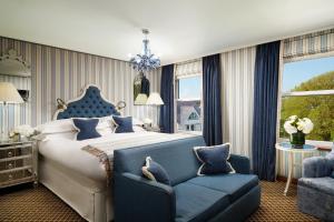 a bedroom with a large bed and a blue couch at Duke Of Richmond Hotel in St Peter Port