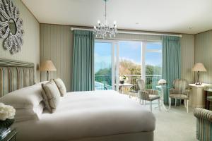 a bedroom with a large white bed and a balcony at Duke Of Richmond Hotel in St. Peter Port