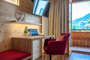 a room with a desk with a laptop and two chairs at Hotel Bergkristall in Silbertal