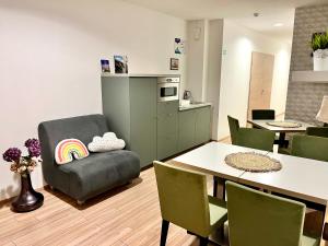 sala de estar con mesa y silla con almohada arcoiris en Pipacs Panír & Grill Garden Vendégház, en Győrújbarát