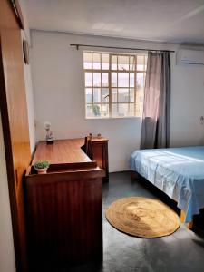 a bedroom with a bed and a table and a window at Port Louis Centre penthouse in Port Louis +6 photos