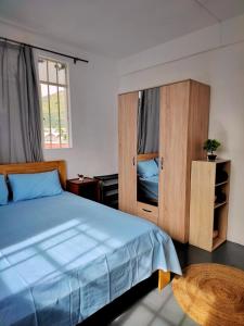 a bedroom with a blue bed and wooden cabinets at Port Louis Centre penthouse in Port Louis