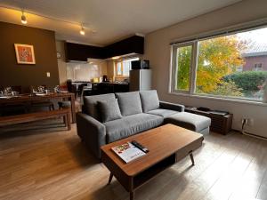 a living room with a couch and a table at Kitanoya Furano in Furano