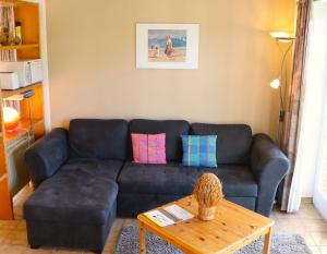 uma sala de estar com um sofá preto e uma mesa em Ferienwohnung Krabbenkutter em Werdum