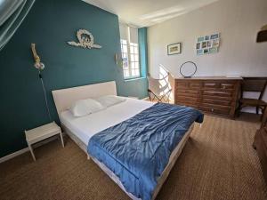 - une chambre avec un lit et un mur bleu dans l'établissement Cosy Cottage -Vue Pyrénées- T5 - Piscine - 8 pers, 