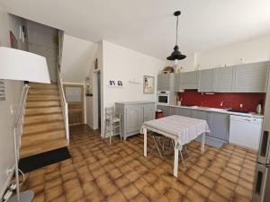 eine Küche mit einem Tisch in der Mitte eines Zimmers in der Unterkunft Cosy Cottage -Vue Pyrénées- T5 - Piscine - 8 pers 