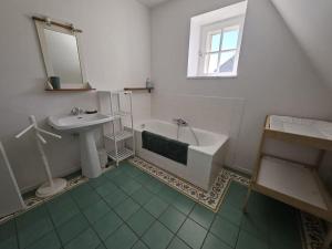 La salle de bains est pourvue d'un lavabo, d'une baignoire et d'un miroir. dans l'établissement Cosy Cottage -Vue Pyrénées- T5 - Piscine - 8 pers, 