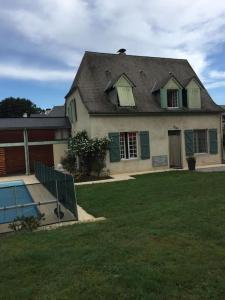 ein Haus mit einem Gameradach und einem Hof in der Unterkunft Cosy Cottage -Vue Pyrénées- T5 - Piscine - 8 pers 