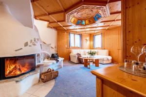 - un salon avec une cheminée et un canapé dans l'établissement Hotel Bergkristall, à Silbertal