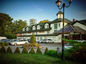 a large building with cars parked in a parking lot at Hotel Verde in Koszalin