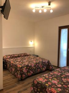 a hotel room with two beds and a window at Hotel I Pionieri in Abetone